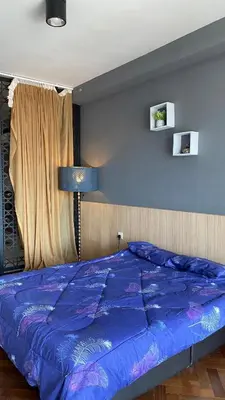 a bed with a blue comforter in a bedroom at The Landmark By Pearl Heritage Homestay & Guest House in Tanjong Tokong