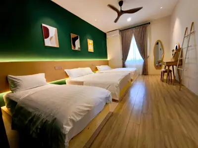 two beds in a room with a green wall at Deer Farm Pool Villa 5BR 27pax by One Life Four Season Guesthouse in Tanjung Rambutan