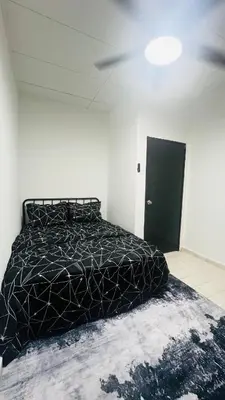 a bedroom with a bed with a black comforter at D'Zebra Homestay Tambun in Kampong Batu Lapan