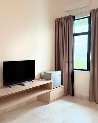a living room with a flat screen tv and a window at Stallions Suite Penang in Jelutong