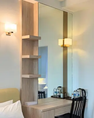 a mirror on a wall next to a desk in a room at Stallions Suite Penang in Jelutong