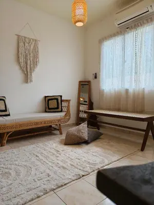 a living room with two beds and a window at Tambun Apartment - Boho Natura in Tambun