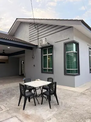a table and chairs in front of a house at PRS Bungalow Homestay in Ipoh