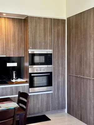 a kitchen with a stove and a microwave at By The Sea partial seaview 2BR 6pax Batu Ferringhi in Batu Ferringhi