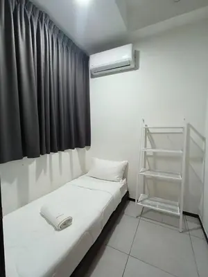a small room with a bed and a shelf at Urban Suites, Penang in George Town