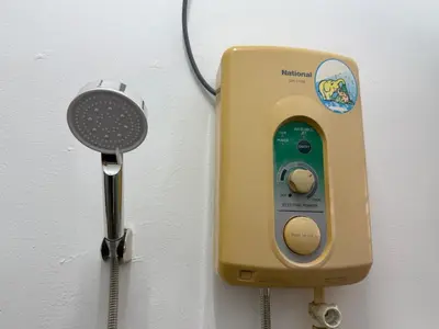 a soap dispenser on a wall next to a microphone at Green Living Homestay Bercham 8 Pax in Ipoh