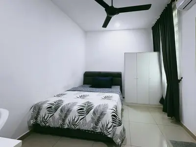 a bedroom with a bed with a black and white comforter at Manjung Cozy Stay in Seri Manjung