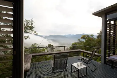 a room with a balcony with two chairs and a table at Mountain View Getaway House with Pool Lauhaus 1 in Kuala Kubu Baharu