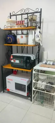 a shelf with a microwave and other appliances in a room at Homestay odah dan hana teluk intan 3R2T in Teluk Intan