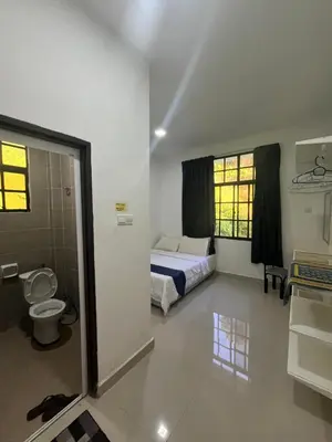 a bedroom with a bed and a toilet in a room at White rose Vila Taman sedia in Tanah Rata