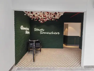 a store with a green wall with a bike parked in front at The Stallionz Classy Suites by LH - Ipoh Town in Ipoh