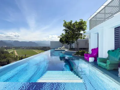 a swimming pool with chairs on the side of a house at Stallionz by KLIQ in Ipoh