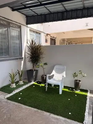 a white chair sitting on top of a patch of grass at PRS Homestay in Chemor