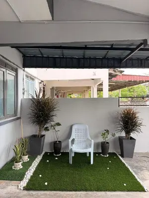 a white chair sitting on a lawn with plants at PRS Homestay in Chemor