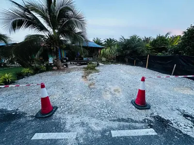 two orange and white traffic cones on a gravel road at Teratak Kasih Kabinstay in Tanjung Karang