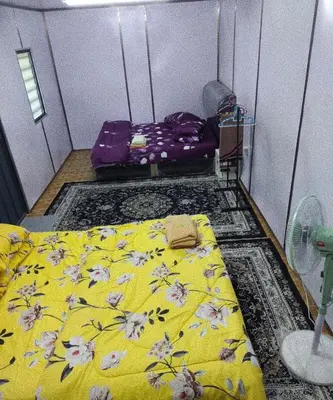 a bedroom with a yellow bed with flowers on it at Teratak Kasih Kabinstay in Tanjung Karang