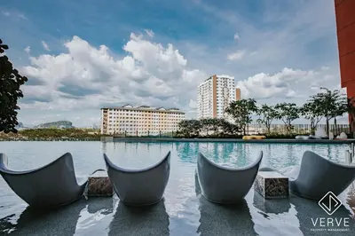 a swimming pool with chairs in front of a building at Ipoh Town Piccadilly Premium Suites by Verve 3B2B in Gua Sai