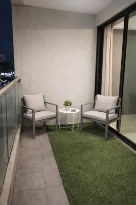 two chairs and a table on a balcony with grass at Kinta Olive in Ipoh