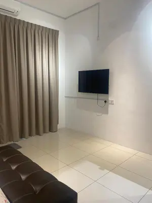 a living room with a couch and a flat screen tv at Sentosa Grand Homestay in Kulim