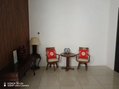 a table and two chairs with red pillows in a room at Sentosa Grand Homestay in Kulim
