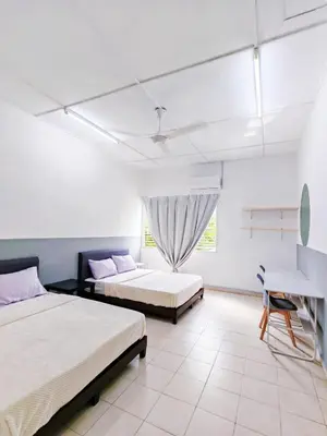 a bedroom with two beds and a chair and a desk at Spacious 9 Rooms house 23paxQbay MallSpice Arena in Gelugor