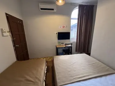 a small room with a bed and a desk at Hotel London Kuala Lipis in Kuala Lipis
