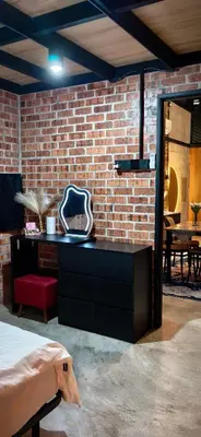 a bedroom with a brick wall and a black dresser at Sekinchan Tiny House in Sekincan