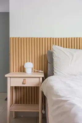 a bed with a night stand next to a side table at Serene Minimalist Family Retreat 2-7pax 8 min to BoH in Brinchang