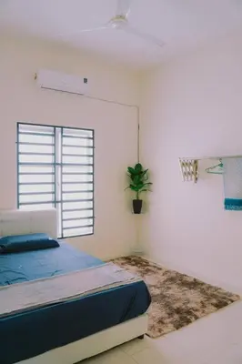 a bedroom with a bed and a potted plant at Wewe Homestay CL2 in Kampung Gajah