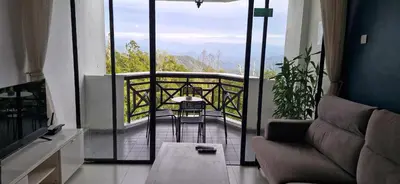 a living room with a balcony with a table and chairs at A321 Silverpark Resort 1 lifted & Mountain view in Bukit Fraser