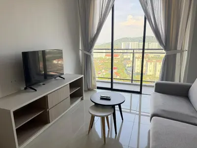 a living room with a couch and a tv and a window at Homey Studio Unit Relaxing Stay at Bayan Lepas in Gua Sai