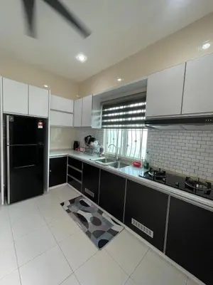 a kitchen with white cabinets and a black refrigerator at Afiq's Homestay, Manjung in Seri Manjung