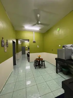 a living room with green walls and a table at Wawa Homestay Ipoh in Ipoh