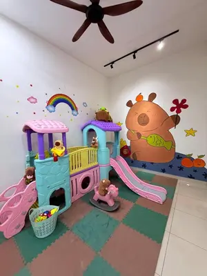 a childs room with toys and a ceiling fan at Pantai Remis Capybara House in Pantai Remis