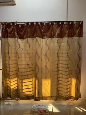 a window with a curtain in a room at happy home in Padang Serai