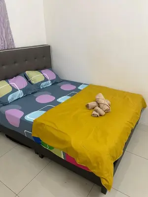a bed with a stuffed animal laying on it at happy home in Padang Serai