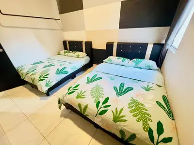 two beds in a small room with at Icolor Ch 7 in Tanah Rata