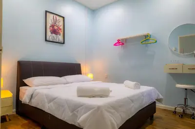 a bedroom with a bed with white sheets and a mirror at Adno Homestay Batu Kawan 2QB1SB in Simpang Ampat