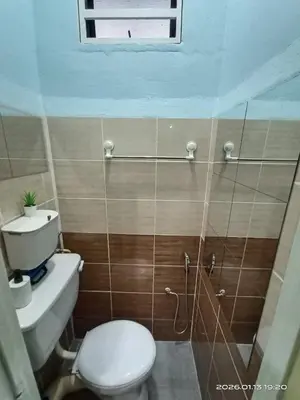 a small bathroom with a toilet and a shower at Adno Homestay Batu Kawan 2QB1SB in Simpang Ampat