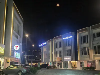 a city at night with cars parked in front of buildings at Piccadilly Green Town Luxury Stay, Ipoh in Ipoh