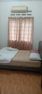 a bed in a room with a window with a radiator at D Seberang Homestay in Perai
