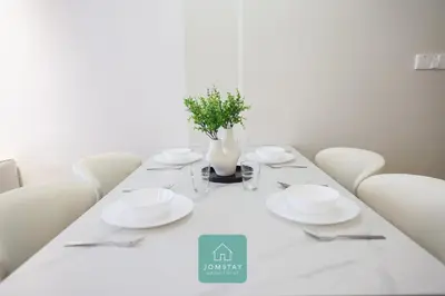 a white table with white plates and a vase on it at JOMSTAY - Piccadilly Greentown Ipoh in Ipoh