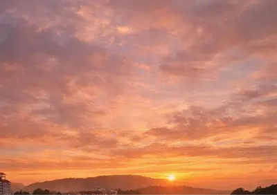 a cloudy sky at sunset with the sun in the background at Homestay Cozy Dino Cameron Highlands in Tanah Rata