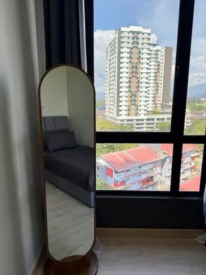 a mirror in a room with a bed and a large window at Piccadilly Ipoh by Iconique in Ipoh