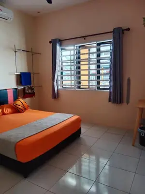 a bedroom with an orange bed and a window at Empatnurul Homestay Ipoh in Ipoh