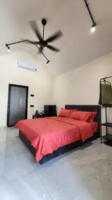 a bedroom with a large red bed with a ceiling fan at Swit60 Homestay in Sungai Besar