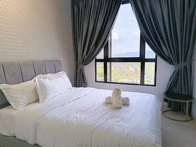 a stuffed animal sitting on a bed with a window at LMS ipoh town in Ipoh