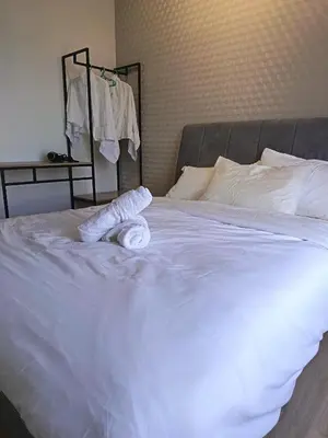 a white bed with two rolled towels on it at LMS ipoh town in Ipoh