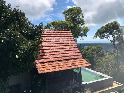 a house with an orange roof and a swimming pool at Bao Sheng Durian Farm in Balik Pulau