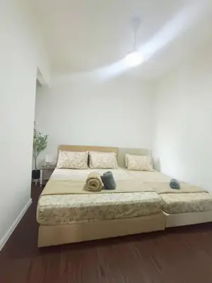 a bedroom with a large bed in a white room at Norlinda palas homestay in Brinchang